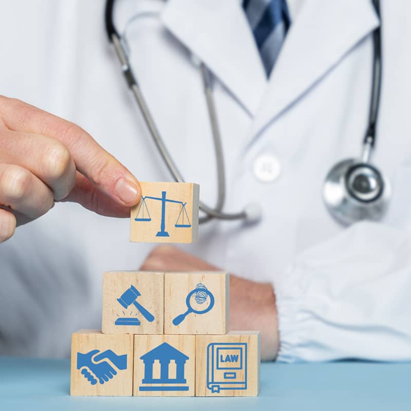 Medical professional holding wooden blocks with medical icons.
