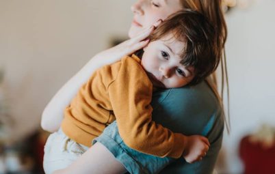 A woman comforting a child in her arms.
