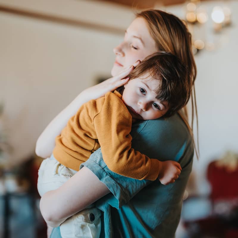 A woman comforting a child in her arms.